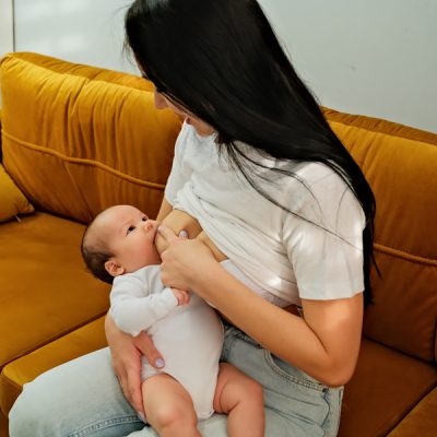 mother holds the child, baby in her arms. feeding a newborn with breast milk. mother is breastfeeding. natural breast milk.