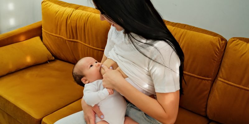 mother holds the child, baby in her arms. feeding a newborn with breast milk. mother is breastfeeding. natural breast milk.