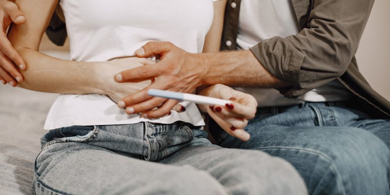 Excited lady telling husband about her pregnancy. People at home. Happy husband.