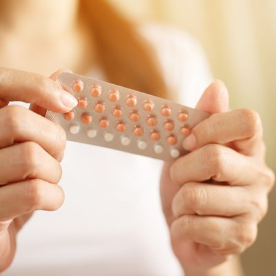 Woman hands opening birth control pills in hand. eating Contraceptive pill. Contraception reduces childbirth and pregnancy concept.