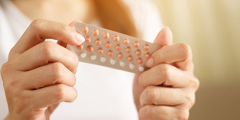 Woman hands opening birth control pills in hand. eating Contraceptive pill. Contraception reduces childbirth and pregnancy concept.